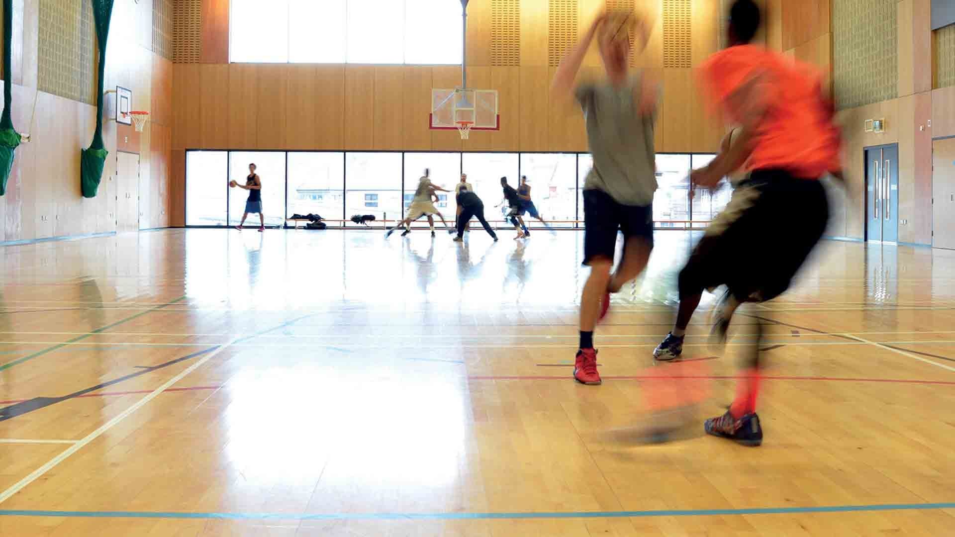 Buckinghamshire New University sports hall with two people playing basketball